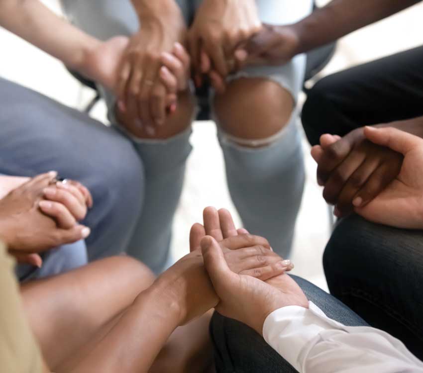 a circle of people holding hands 